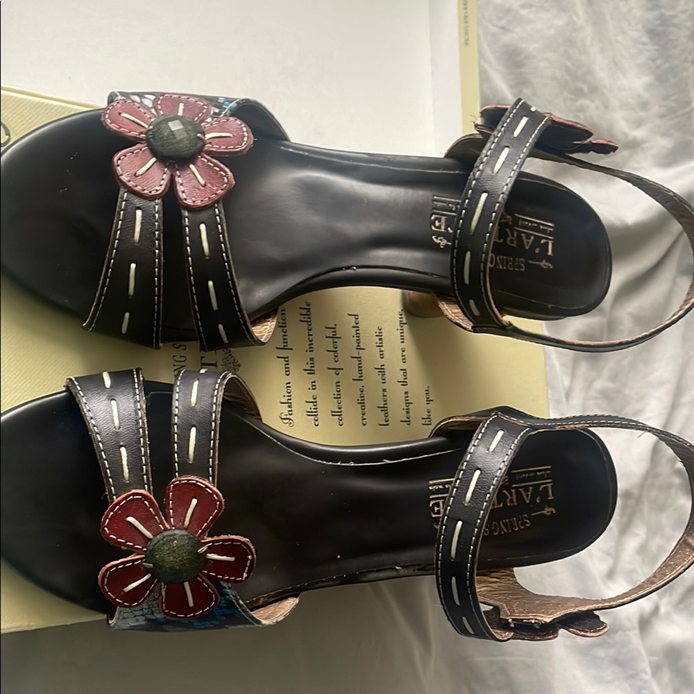 L’artiste Black Sandals with Floral Accents and Ankle Strap